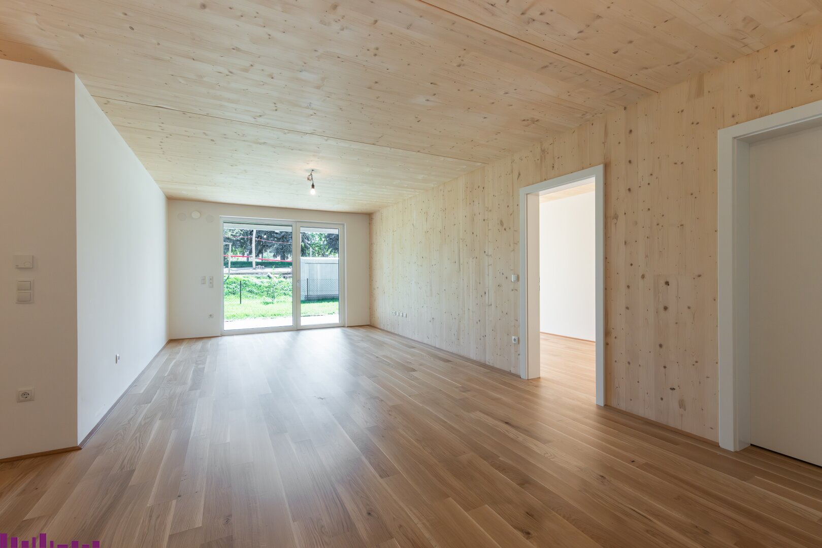 Wohnzimmer mit Sichtholzdecke und Holzboden