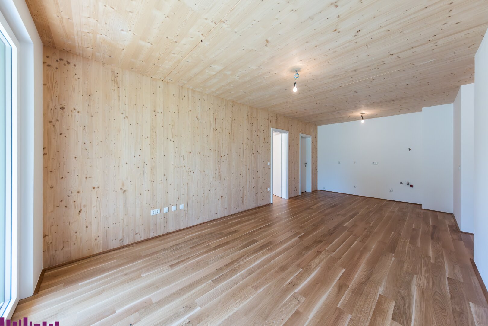 Zimmer mit Sichtholzdecke und Holzboden