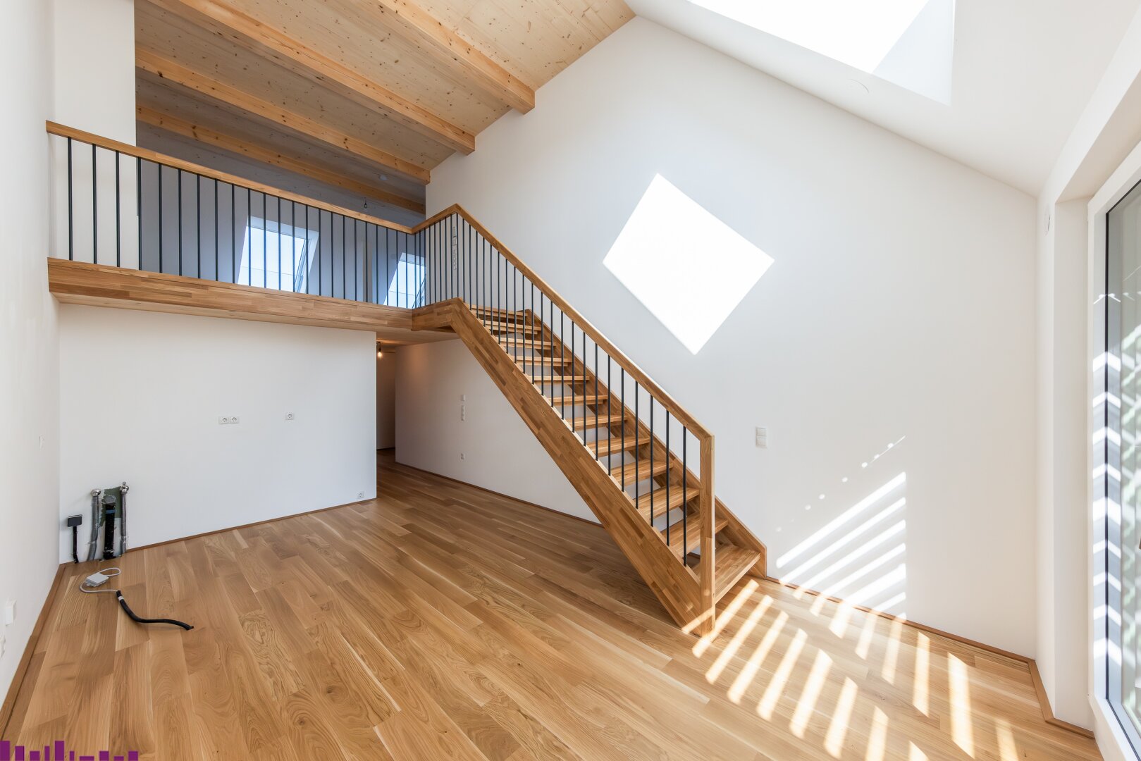 Zimmer mit Sichtholzdecke und Holzboden sowie Treppe