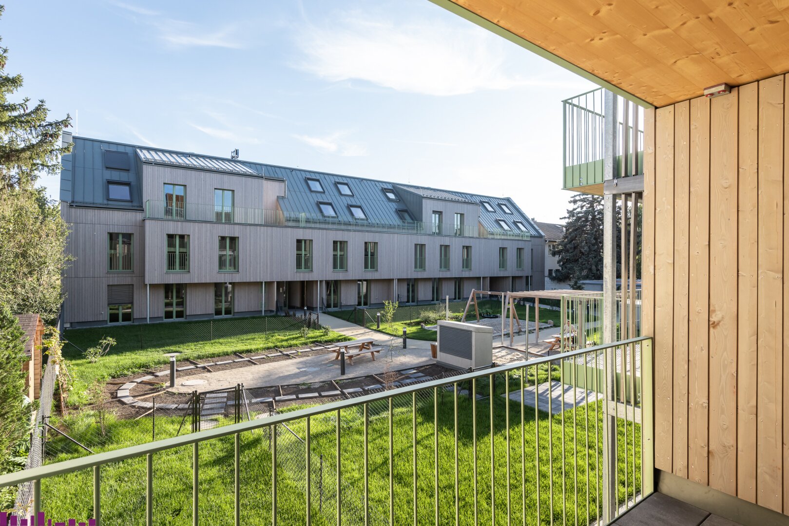 Blick vom Balkon mit Holzelementen in den Innenhof